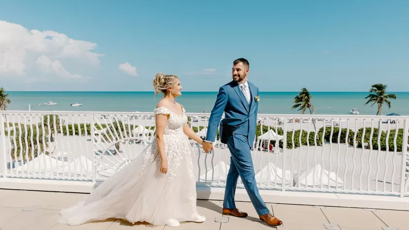 bride and groom hand in hand 3rd floor terrace overlooking gulf sundial sanibel